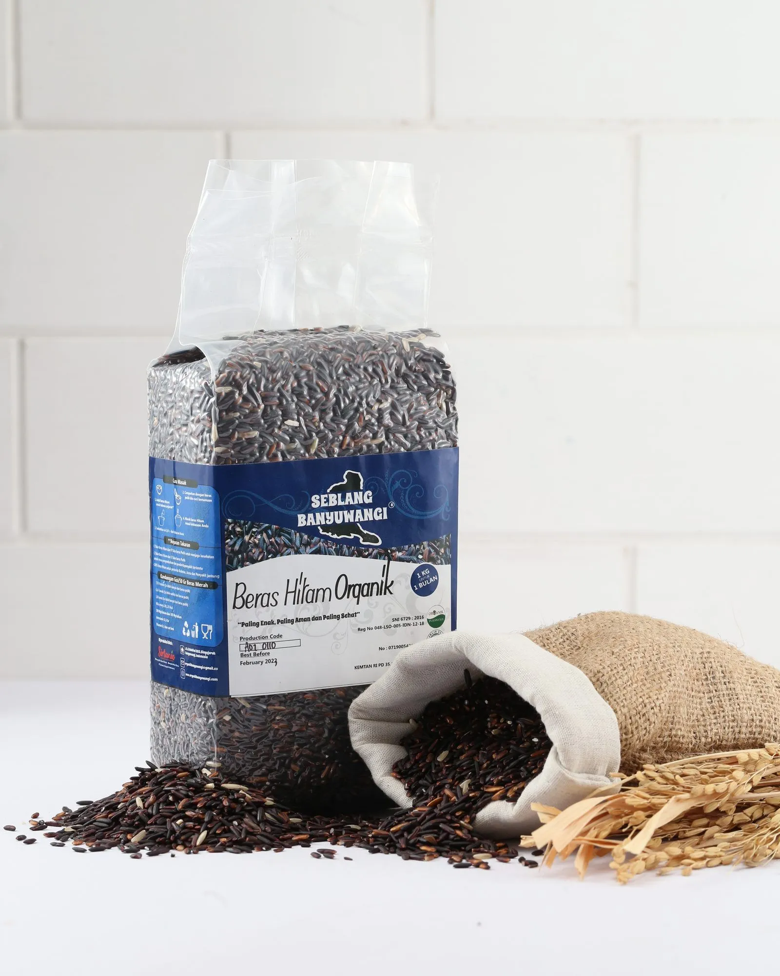 A one-kilogram pack of Sirtanio organic black rice standing beside a jute sack of spilled black rice